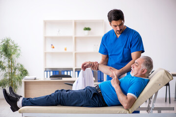 Obraz premium Old male patient visiting young male doctor