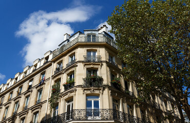The facade of traditional French house with typical balconies and windows. Paris.