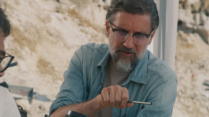 Mature archaeologist discussing fossil with colleague
