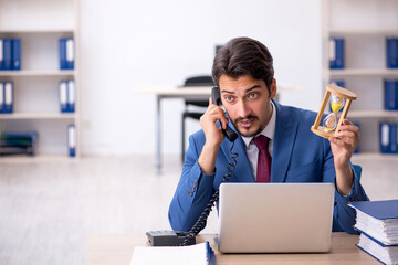 Fototapeta premium Young male employee in time management concept