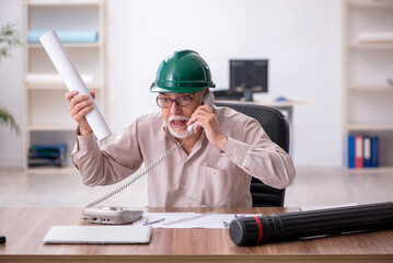 Old male architect working in the office