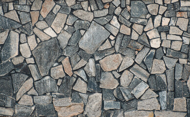 Texture of a stone. Old stone wall texture background. Grey stone wall as a background or texture. Stone wall of natural stones in different sizes. Side covering with natural stones.