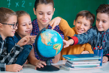 Students look at the globe in the classroom.