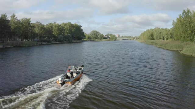 Motorboat racing in river Daugava city Riga. Fishermen event. Speedboat riding fast creating waves and trail. 