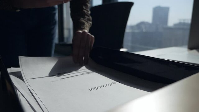 Female employee in espionage concept. Female hands take pictures of confidential documents in the office.Slow motion