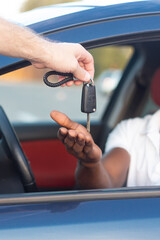 The key to the car is in the hands of an African-American. Buying and renting a car