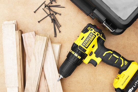 Stanley's new cordless screwdriver on wood background.