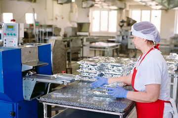 Naklejka na ściany i meble Confectionery factory. Packaging conveyor of sweets in plastic packaging.
