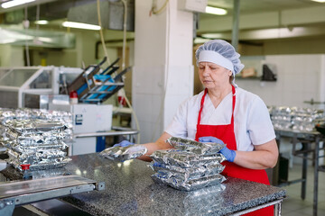 Confectionery factory. Packaging conveyor of sweets in plastic packaging.