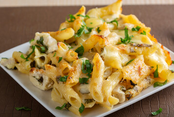 Penne pasta with chicken, cream and cheese on plate