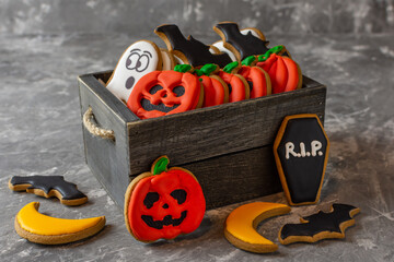 sweets gingerbread for halloween pumpkin ghost moon coffin bat in a wooden box on a gray stone background 