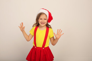 a beautiful girl in a Santa hat in a red skirt yellow jacket colored striped socks new year