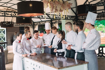 Restaurant manager and his staff in terrace. interacting to head chef in restaurant.