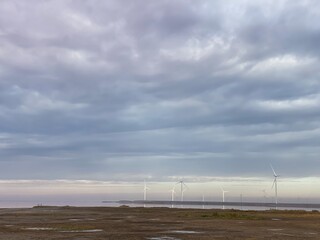 wind turbines in the field bright summer day beautiful sky and pink lake near