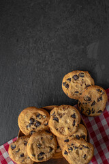 American biscuits with chocolate pieces on tablecloth and dark background
