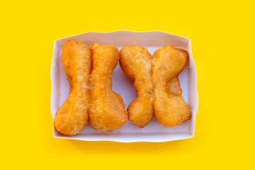 Deep-fried dough sticks or chinese bread sticks on yellow background.