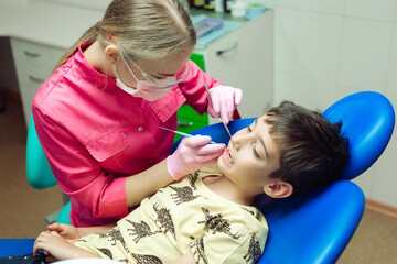 Obraz na płótnie Canvas Teenager boy patient at the dentist. A boy with problem teeth sitting in a dental chair.
