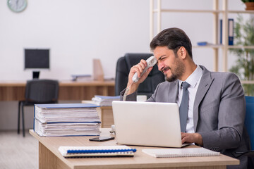 Naklejka premium Young male employee working in the office