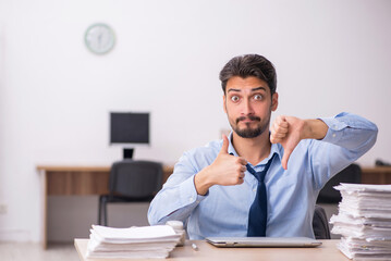 Young male employee and too much work in the office