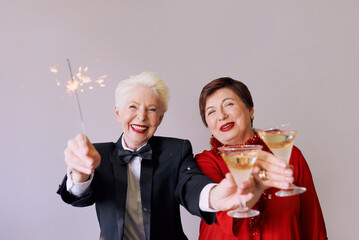 Two beautiful stylish mature senior women celebrating new year. Fun, party, style, celebration...