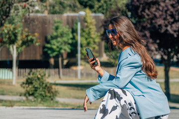 young girl crouching squatting with mobile phone