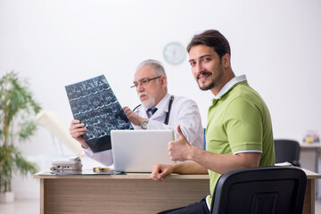 Young man visiting old male doctor radiologist
