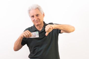 elderly man holding 200 Brazilian reais banknote with gesture in use of the great currency...