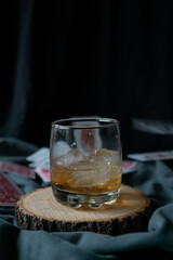 whiskey glass in an elegant setting with poker cards in the background