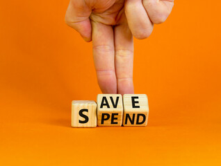 Save or spend symbol. Businessman turns wooden cubes and changes the concept word 'spend' to 'save' on a beautiful orange background. Copy space. Business and save or spend concept.