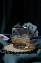 whiskey glass in an elegant setting with poker cards in the background