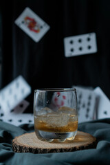 whiskey glass in an elegant setting with poker cards in the background