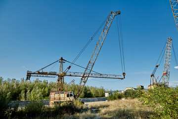 Rusty cranes in an abandoned hydrotechnical construction site.