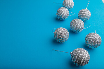 Christmas or New Year composition. Decorations, silver balls, on a blue background. Side view, copy space.