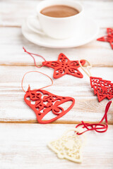 Christmas or New Year composition. Decorations, red stars, bells, on a white wooden background. Side view, copy space, selective focus.