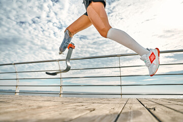 Life is in your hands. Cropped photo of disabled woman with bionic leg in sportswear is running on...