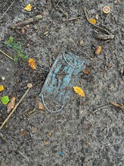 Obraz premium Vertical top view shot of a medical face mask laying in the dirt on the ground