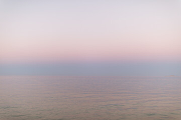 Peaceful sunset at the ocean. Pastel pink gradient from water to sky. Abstract minimalist...