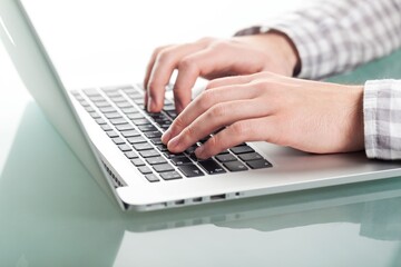 Person's hands typing on laptop computer