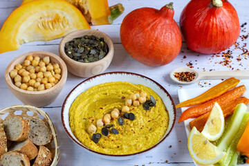 Homemade hummus from chickpeas and pumpkin with vegetables. Autumn pumpkin snacks. Vegetarian cooking