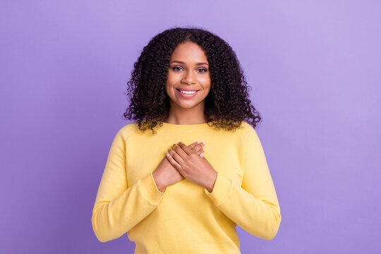 Photo of peaceful charming dark skin woman wear yellow sweater smiling arms chest isolated violet color background