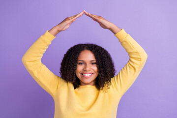 Fototapeta na wymiar Portrait of young cheerful positive good mood afro female hold hands roof safe new home isolated on violet color background