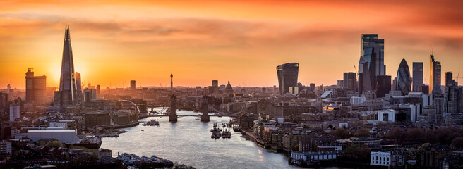 Golden sunset behind the modern skyline of London, with Tower Bridge, Thames river and City...