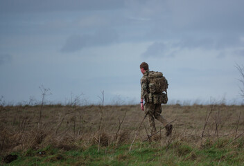British army soldier completing an 8 mile tabbing exercise with fully loaded 25Kg bergen, Wiltshire UK