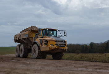 large yellow articulated dump truck earth mover truck in action Wiltshire UK 