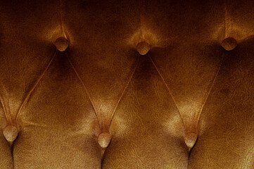 Fototapeta premium Dark natural luxury leather sofa textured background with faded light. Long exposure shot