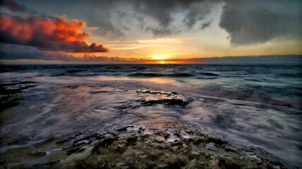 Sun Rising over the sea and the horizon displaying the color and beauty in the sky. The 