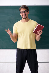 Young male student in front of blackboard