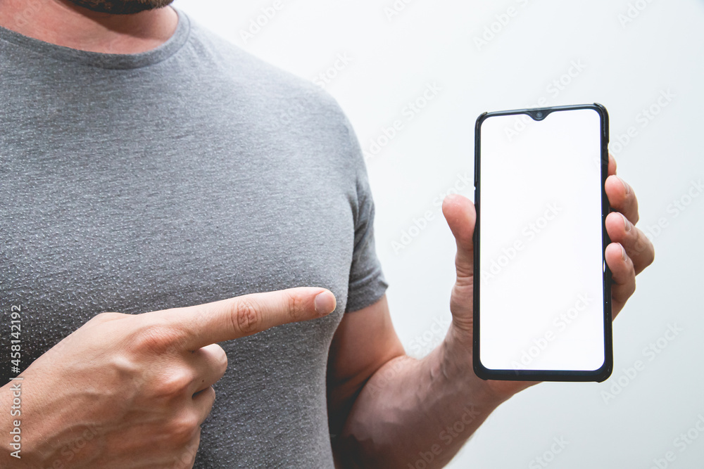 Poster view of a person wearing a grey t-shirt holding a smartphone in his hands on a white background