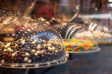Showcase of a candy store. Nuts and raisins in chocolate