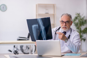 Obraz premium Old male doctor radiologist working at the hospital
